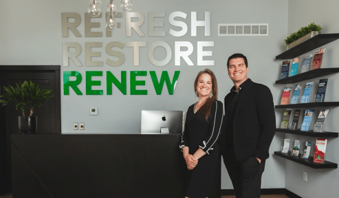 Two business owners in front of their store front.