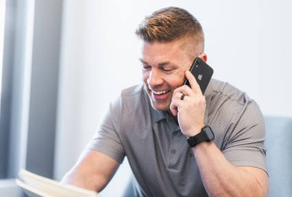 A man on the smiling while he's on the phone