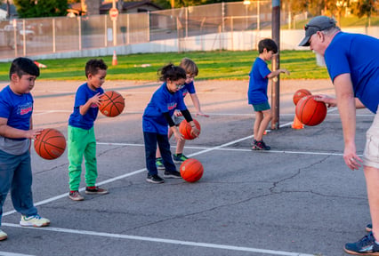 Kids and their coach playing basketball