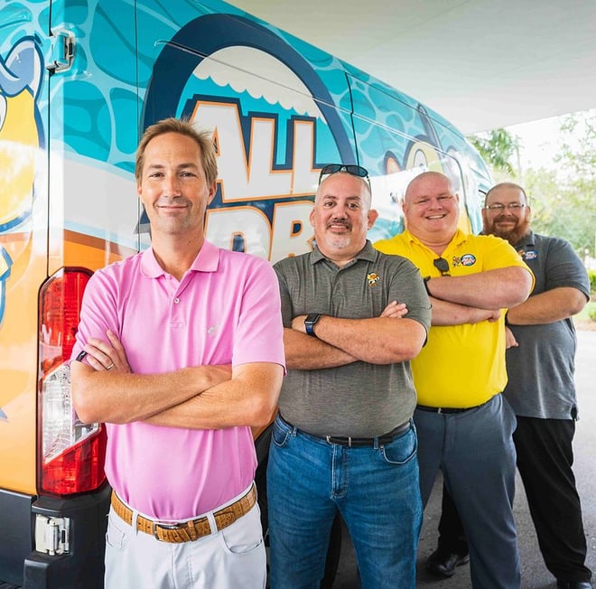 All Dry founding team members stand cross armed in front of an All Dry branded van.