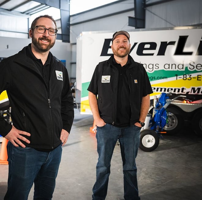 Two EverLine founding team members stand in front of EverLine branded truck.