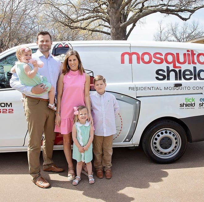 Husband and wife Mosquito Shield franchisees stand with their three children in front of their Mosquito Shield branded van.