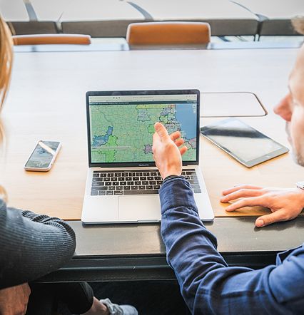 man and woman looking at locations on laptop