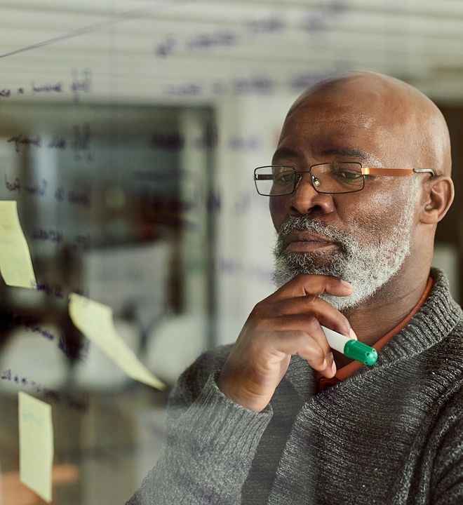 man planning and strategizing ideas on wall