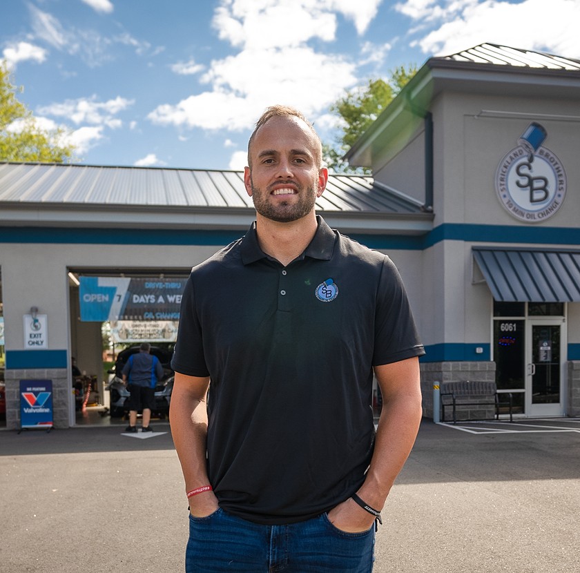 man standing in front of his business