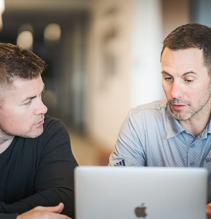 team members wroking together on laptop