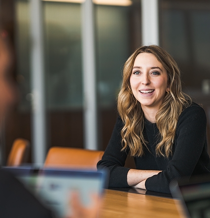 woman smiling and talking to colleague