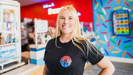 DonutNV Founder stands inside colorful store in a DonutNV logo t-shirt.