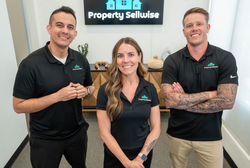 Three employees from Property Sellwise posing in the office entry way