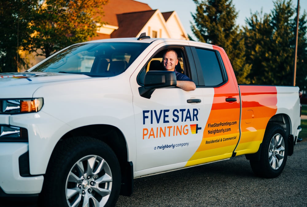 A guy in a Five Star Painting truck