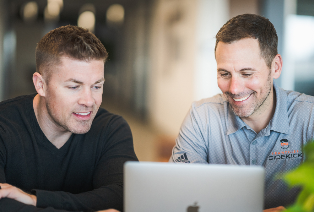 Two men looking at a laptop 