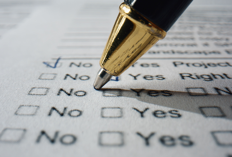 The tip of a pen writing on a form